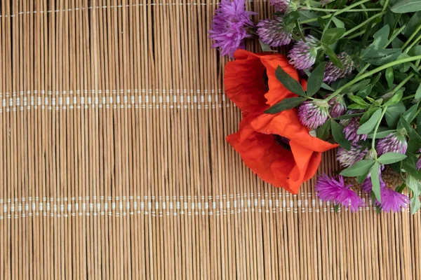 Vor Dem Hintergrund Einer Strohserviette Liegt Ein Strauß Aus Mohn — Stockfoto