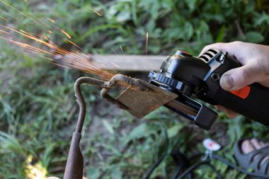 Eski bir bahçe çapa aletini öğütücüyle keskinleştirmek.