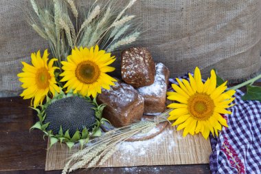 Masada ekmek var, ayçekirdeği, un, buğday kulağı, ayçiçeği ve olgun çekirdekli bir ayçiçeği başıyla pişirilmiş..