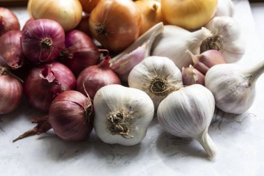 Beyaz arka planda iki çeşit soğan ve sarımsak vardır.