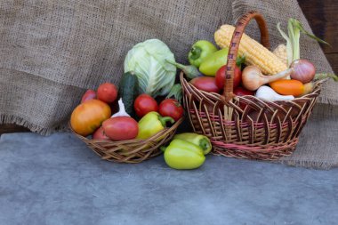 Sepette ve tabakta sebzeler var - mısır, lahana, sarımsak, soğan, patlıcan, biber, domates, salatalık