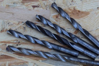 Aynı çapta beş metal matkap ahşap bir zeminde yatıyor..