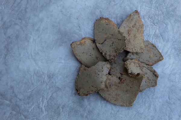 Gri arka planda, doğal yeşil işlenmemiş kil levhalar.