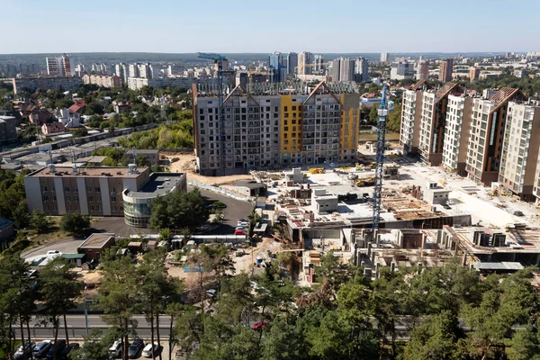 Harkov, Ukrayna. 13 Eylül 2020. Üst Manzara. Şehir manzarası. Yeşil ağaçlar arasında çok katlı çok katlı binalar inşa ediliyor. Turnalar evlerin yanında görünüyor..