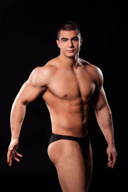 Genç gömleksiz vücut geliştirmeci poz.
