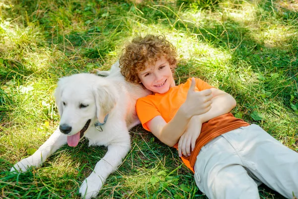 Mignon garçon mensonges sur son chien — Photo