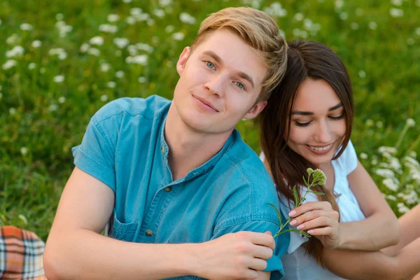 Blond kille ger en blomma till sin flickvän — Stockfoto