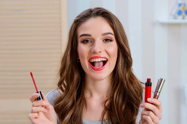 Lauhing woman holding lip gloss — Stock Photo, Image