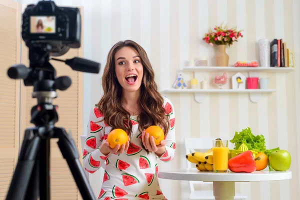 Mujer joven sosteniendo dos naranjas —  Fotos de Stock