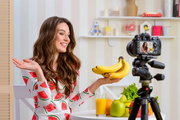 Mujer sonriente sosteniendo plátanos —  Fotos de Stock