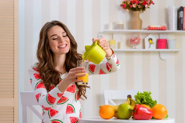 Mujer joven vertiendo jugo —  Fotos de Stock