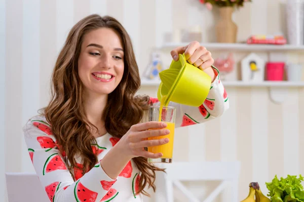 Mujer joven vertiendo jugo —  Fotos de Stock