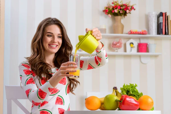 Chica vertiendo jugo de naranja fresco —  Fotos de Stock