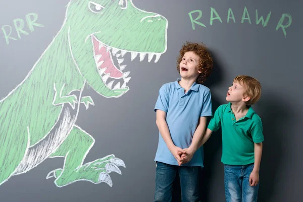 Rémült fiúk és hatalmas dinoszaurusz — Stock Fotó