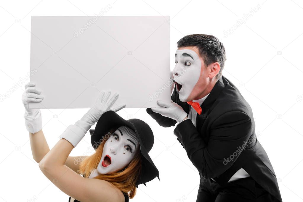 Surprised mimes holding blank placard