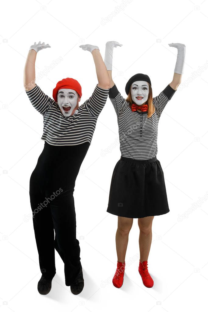 Smiling mimes holding something heavy