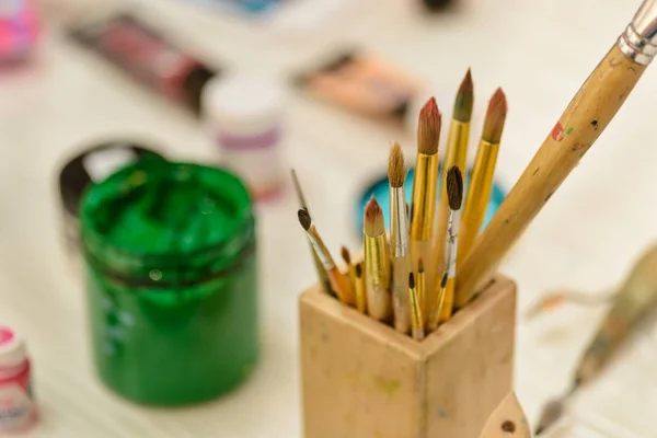 Brushes and green paint jar — Stock Photo, Image