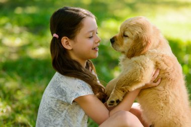 Çocuk bir köpek yavrusu tutuyor