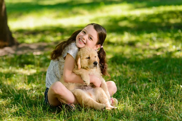 Ragazza gioiosa abbraccia il suo animale domestico — Foto Stock