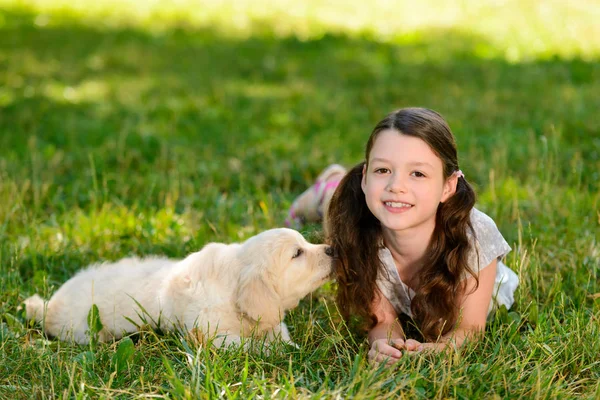 Fille et chien étendu sur l'herbe — Photo