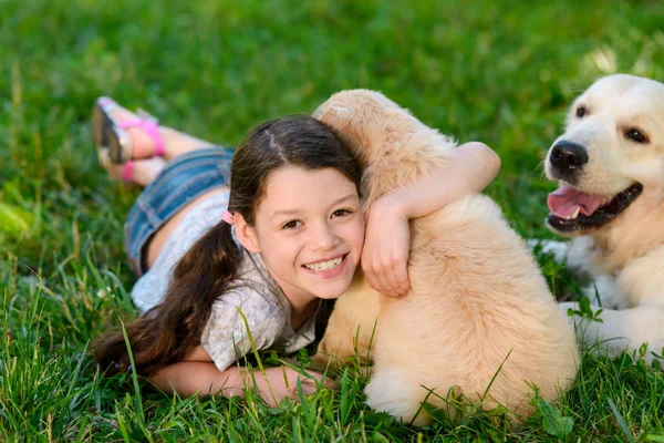 Улыбающийся ребенок обнимает щенка — стоковое фото