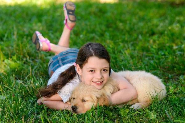 잔디에 소녀입니다 리트리버 강아지 활기찬 공원에서 — 스톡 사진
