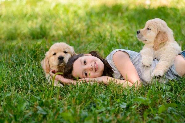 Девочка и собаки на траве — стоковое фото