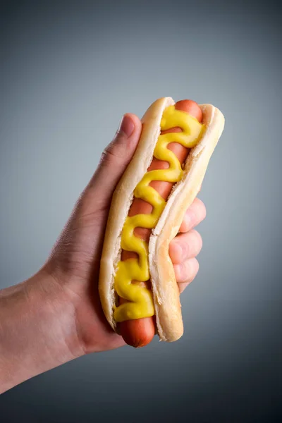 Mannenhand bedrijf hotdog — Stockfoto