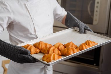 Nefis ve gevrek kruvasan, taze pişmiş malların tepsi. Fransız tarifi, profesyonel baker tarafından yapılan sonucu.