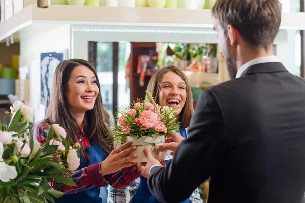 Gelukkig bloemisten geven van bloemen — Stockfoto