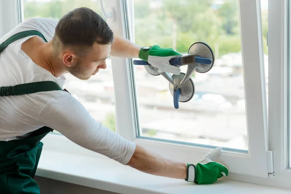 Young worker is repairing window — Stock Photo, Image