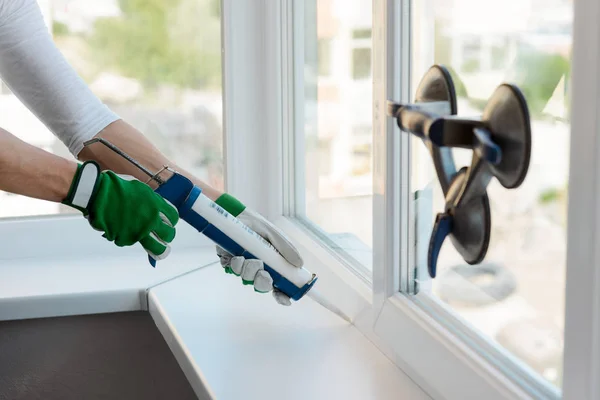 Manos aplicando sellador de silicona — Foto de Stock