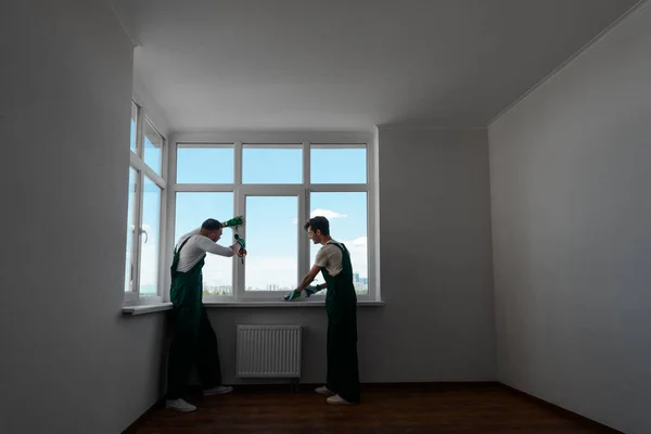Zwei Männer befestigen Fenster — Stockfoto