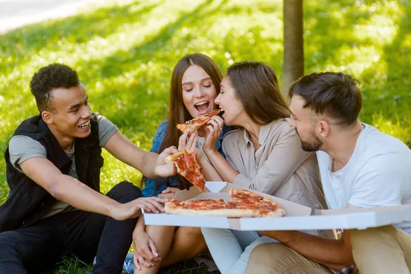 Friends taking slices of pizza