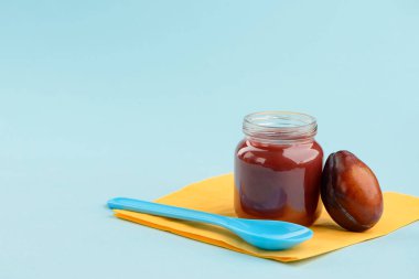 Kavanozlu püresi, Erik ve mavi arka plan kopya alanı ile kaşık. Tatlı lezzet ve bebek beslenmesi için vitaminler.