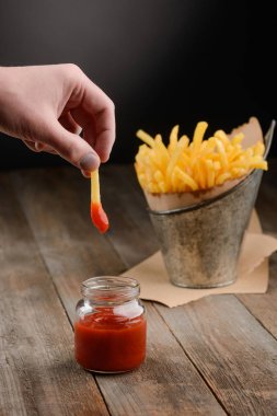 Patates kızartması elini daldırıyor