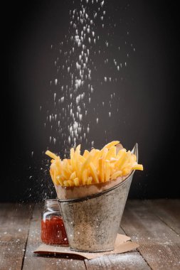 Patates kızartması üzerinde tutam tuz
