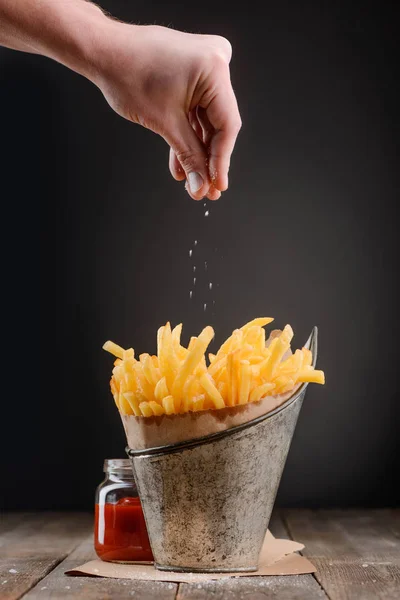 Hand sprinkles pinch of salt — Stock Photo, Image