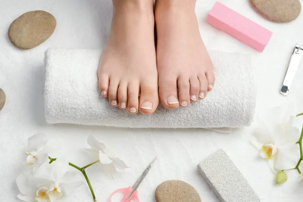 Female feet on towel roll — Stock Photo, Image