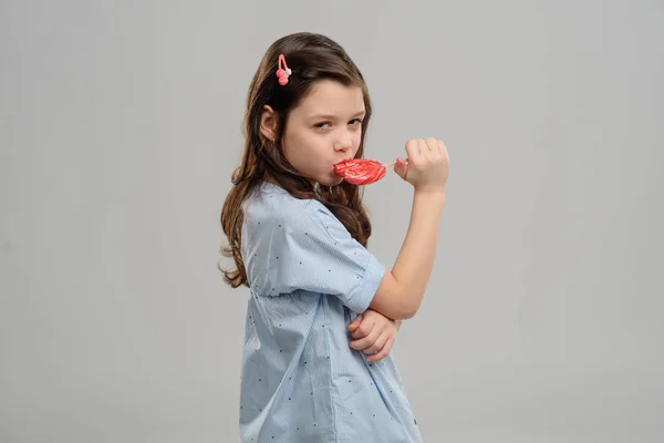 Menina comendo um doce duro — Fotografia de Stock
