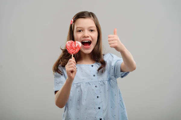 Girl showing a lollipop — Stockfoto