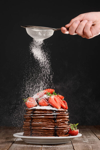 Hand sprinkles powdered sugar