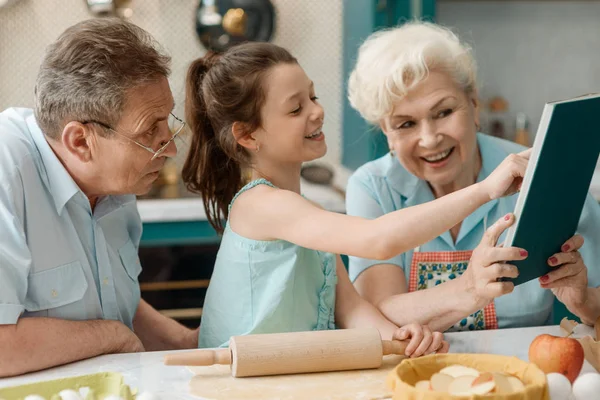 Nieta y abuelos cocinando juntos — Foto de Stock