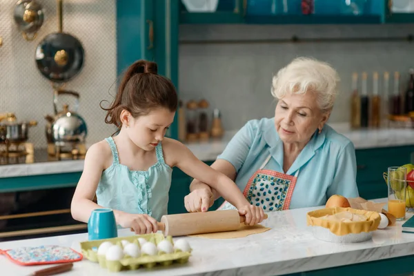 Granny teaches granddaughter to bake