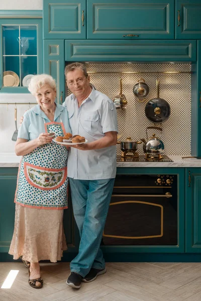 Vrolijke grootouders in hun keuken — Stockfoto