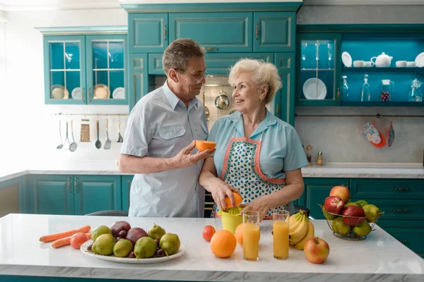 Pareja mayor apretando naranjas — Foto de Stock