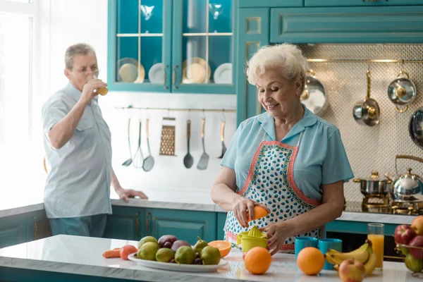 Abuela apretando una mitad naranja —  Fotos de Stock