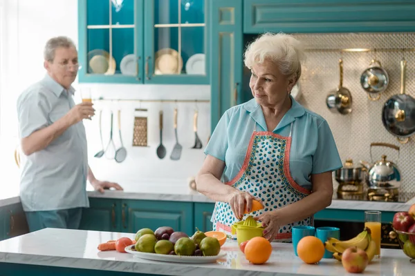 Oude vrouw knijpen een sinaasappel — Stockfoto