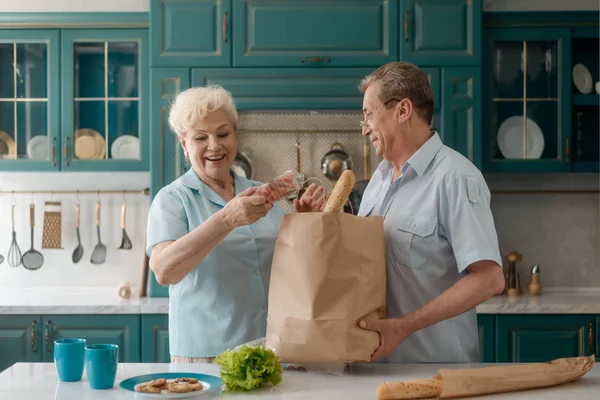 Pareja mayor tomando comestibles — Foto de Stock