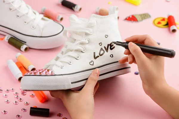 Dziewczyna Rysowanie na białe buty sportowe — Zdjęcie stockowe